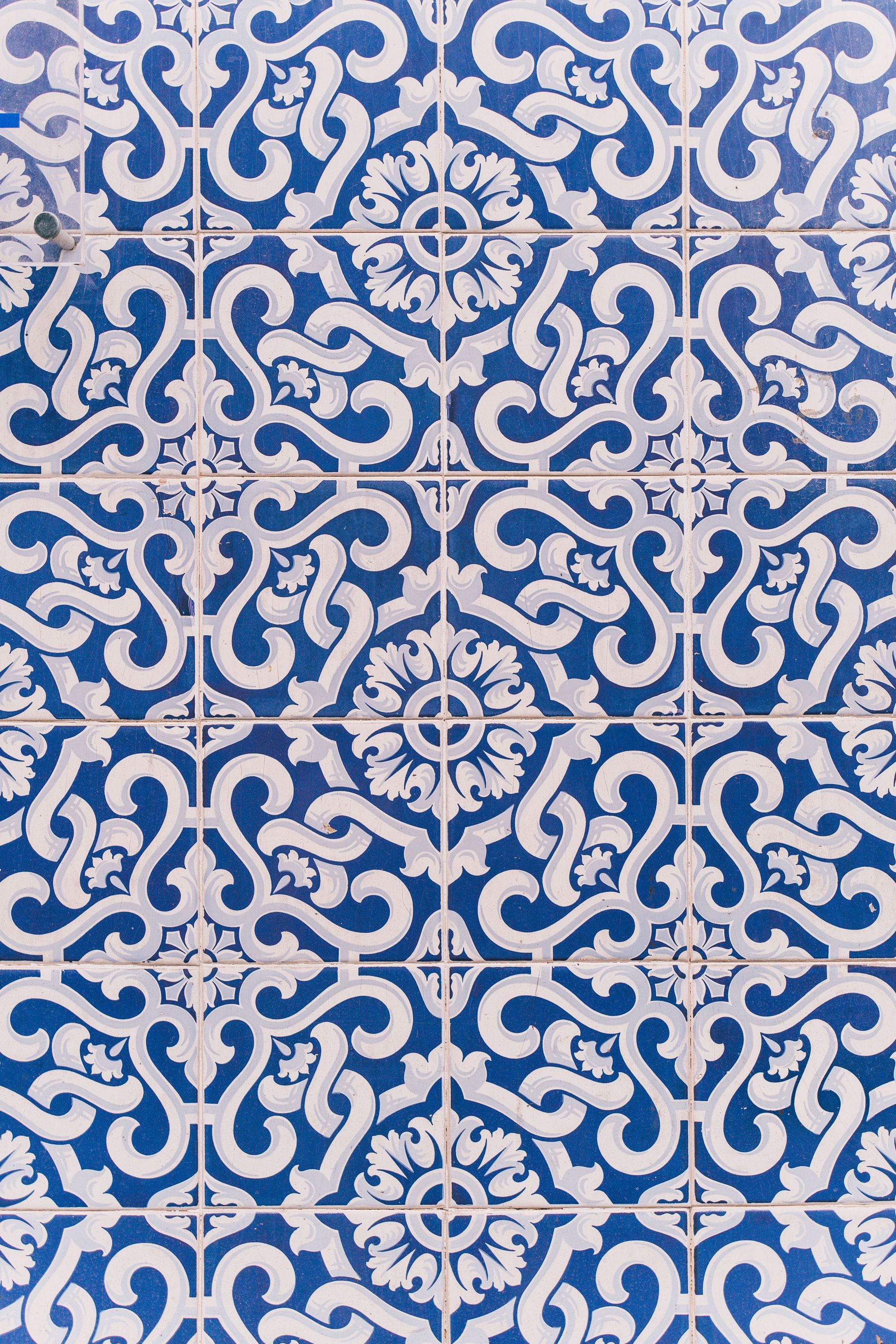 Detailed blue and white decorative tile pattern with geometric floral design, ideal for background or wallpaper.
